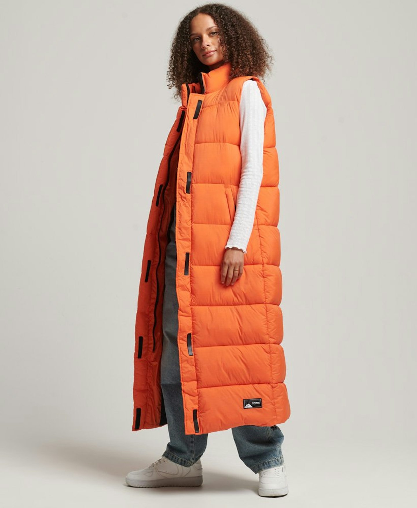 Model wearing orange longline puffer gilet