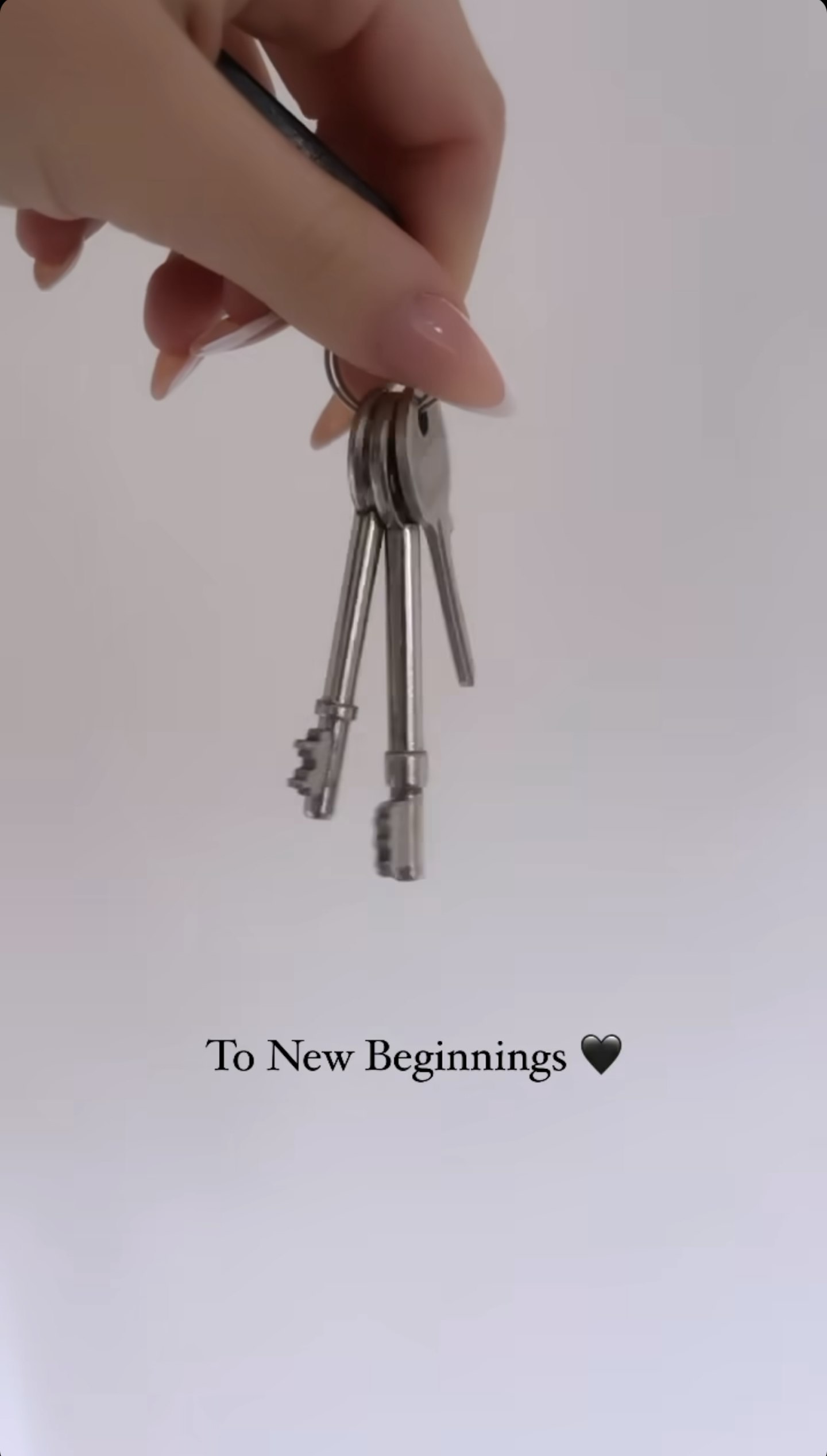 Ella Rae Wise's hand holding a set of keys with the caption 'new beginnings'