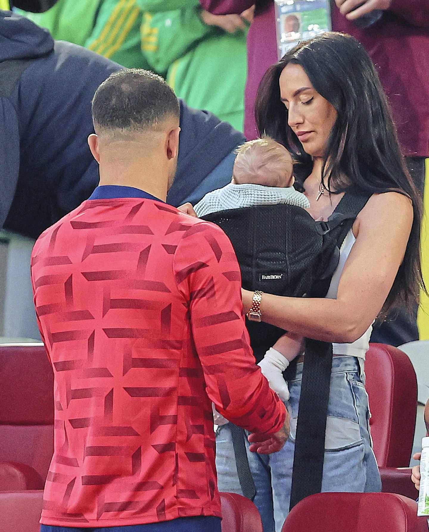 kyle walker and annie kilner holding their baby at a football game