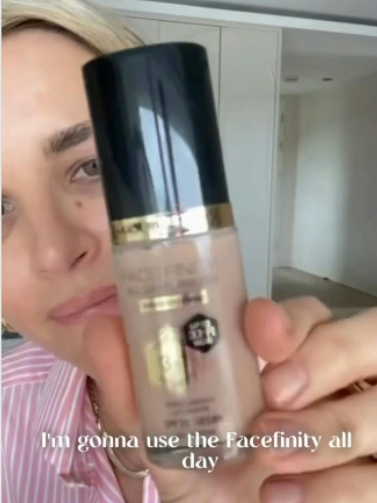 vogue williams poses with a bottle of foundation