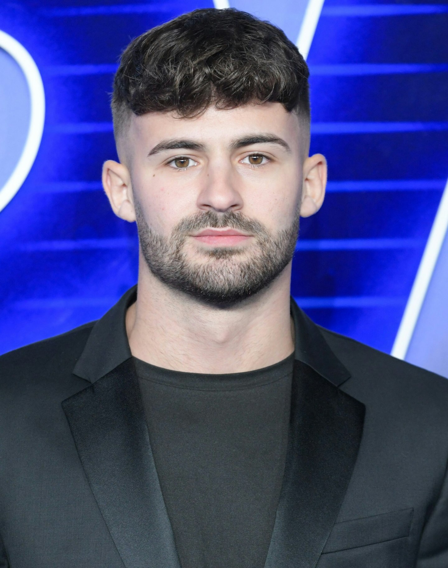 Ciaran Davies wears a black t-shirt and suit jacket