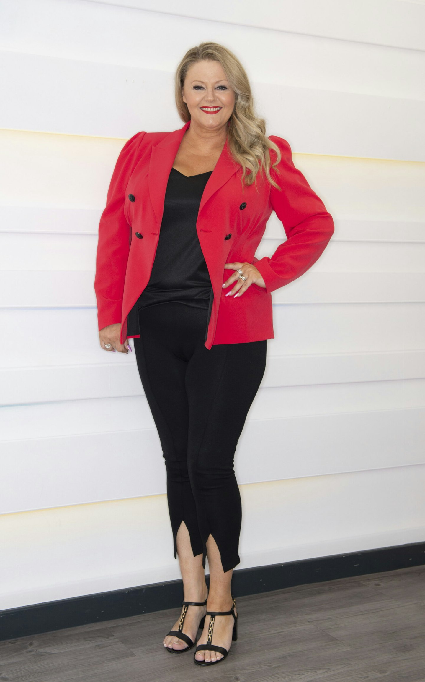 Debbie Davies posing in a red jacket