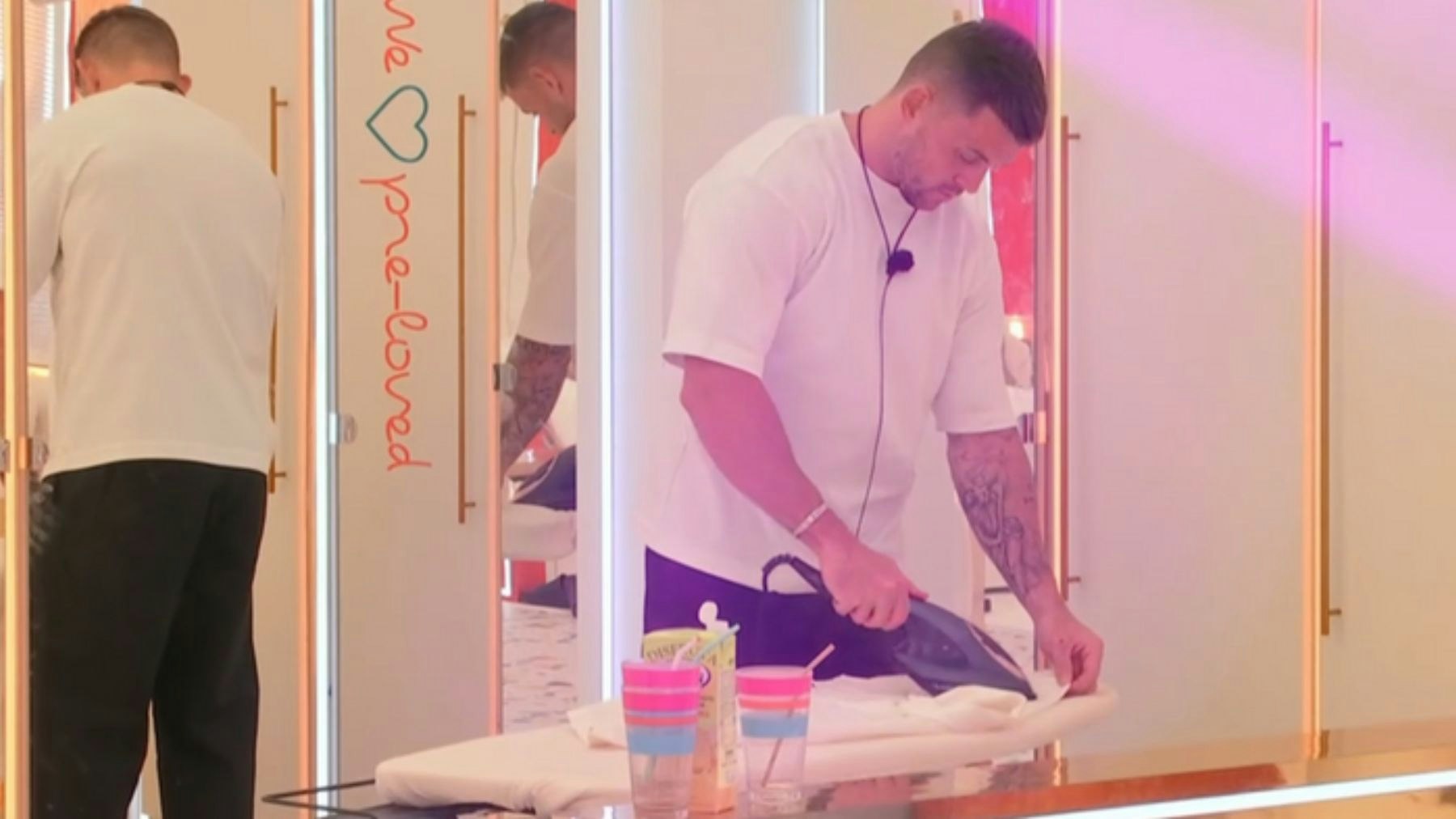 Giorgio using the Russell Hobbs Steam Genie to get creases out of his clothes in the Love Island villa