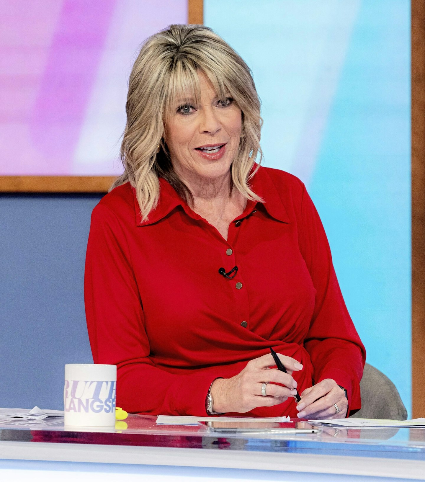 ruth langsford smiles wearing a red top