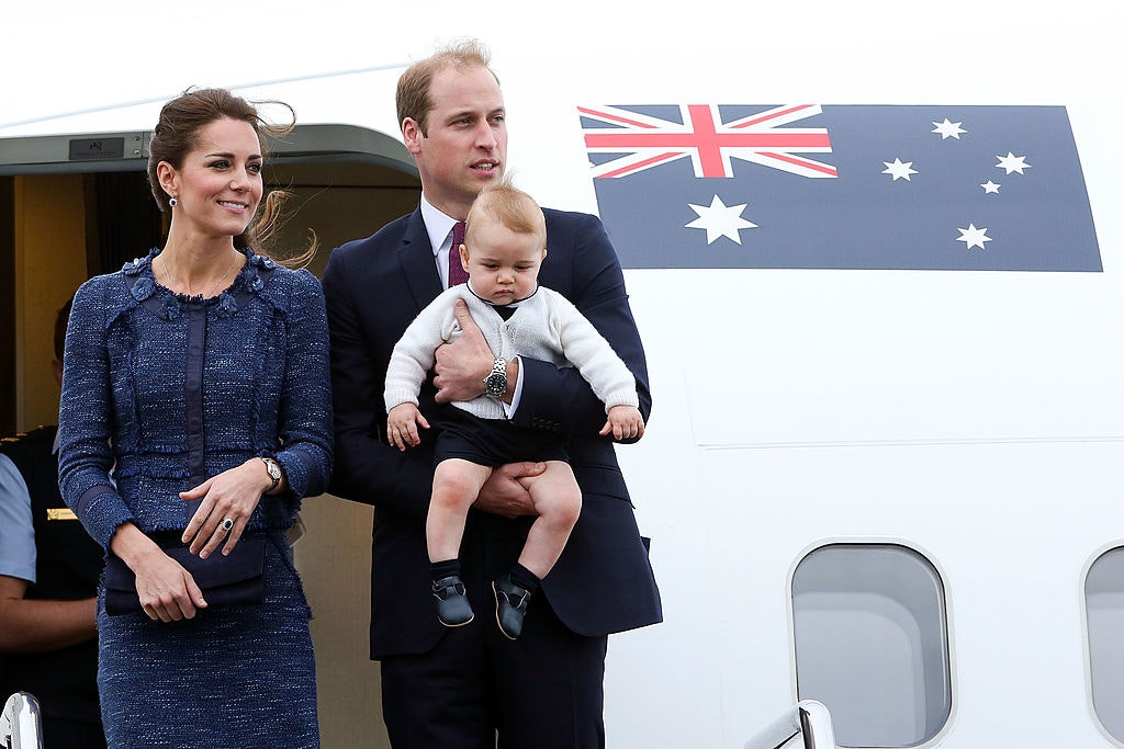 Catherine, Duchess of Cambridge, Prince William, Duke of Cambridge and Prince George of Cambridge look on before boarding a Royal Australian Air Force plane for their flight to Australia