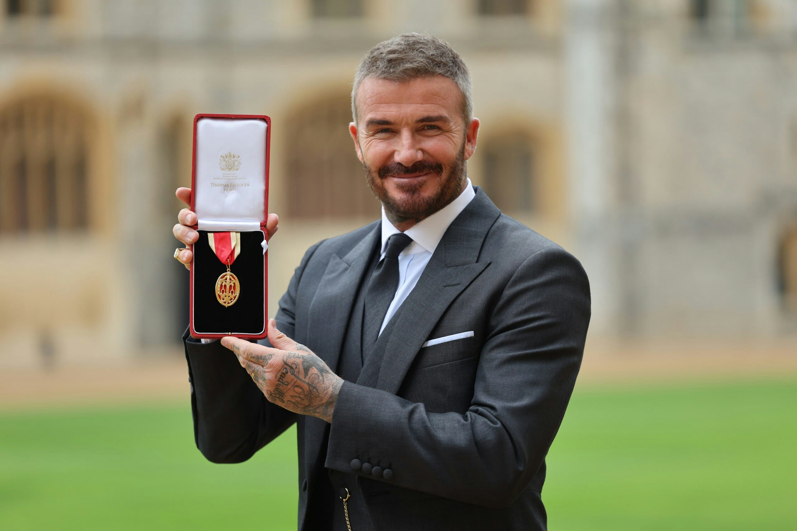 Sir David Beckham poses with his medal after receiving his knighthood