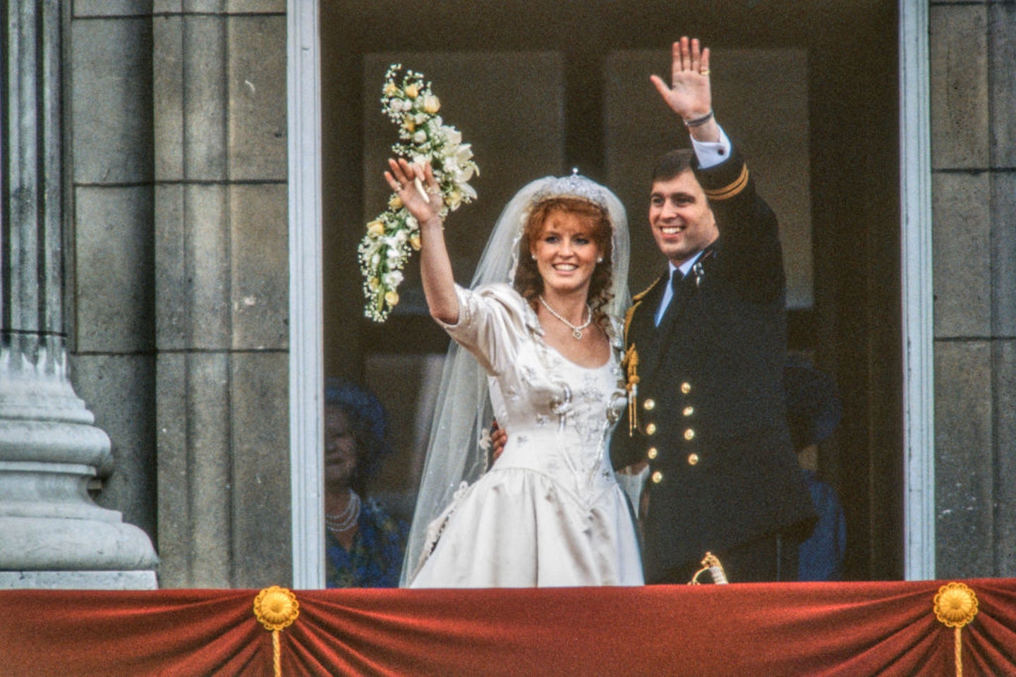 View of just-married couple Sarah, Duchess of York, and Prince Andrew, Duke of York, as they wave from the balcony of Buckingham Palace