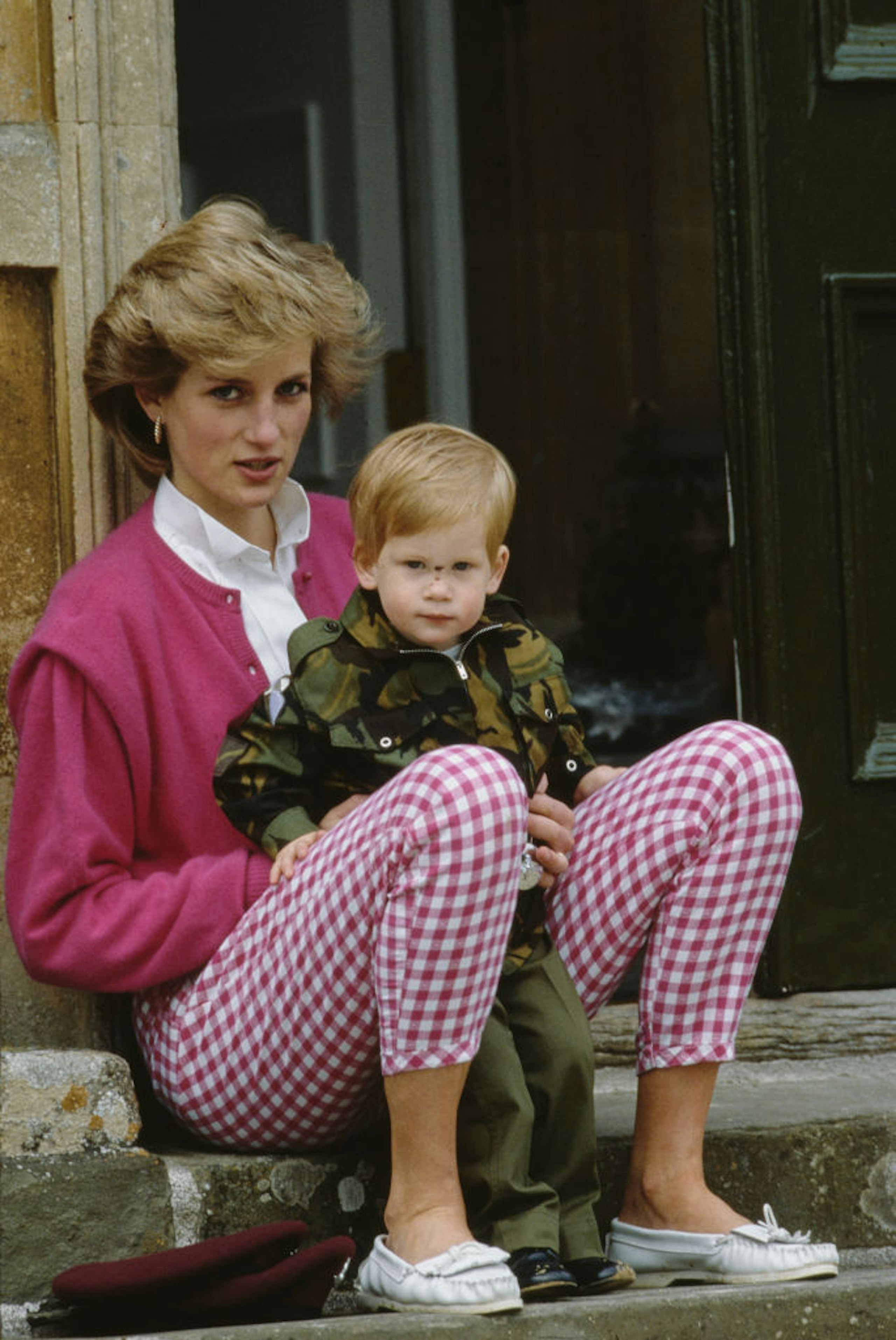 Princess Diane sits on a step with Prince Harry on her lap at Highgrove Estate, Doughton, Gloucestershire, England