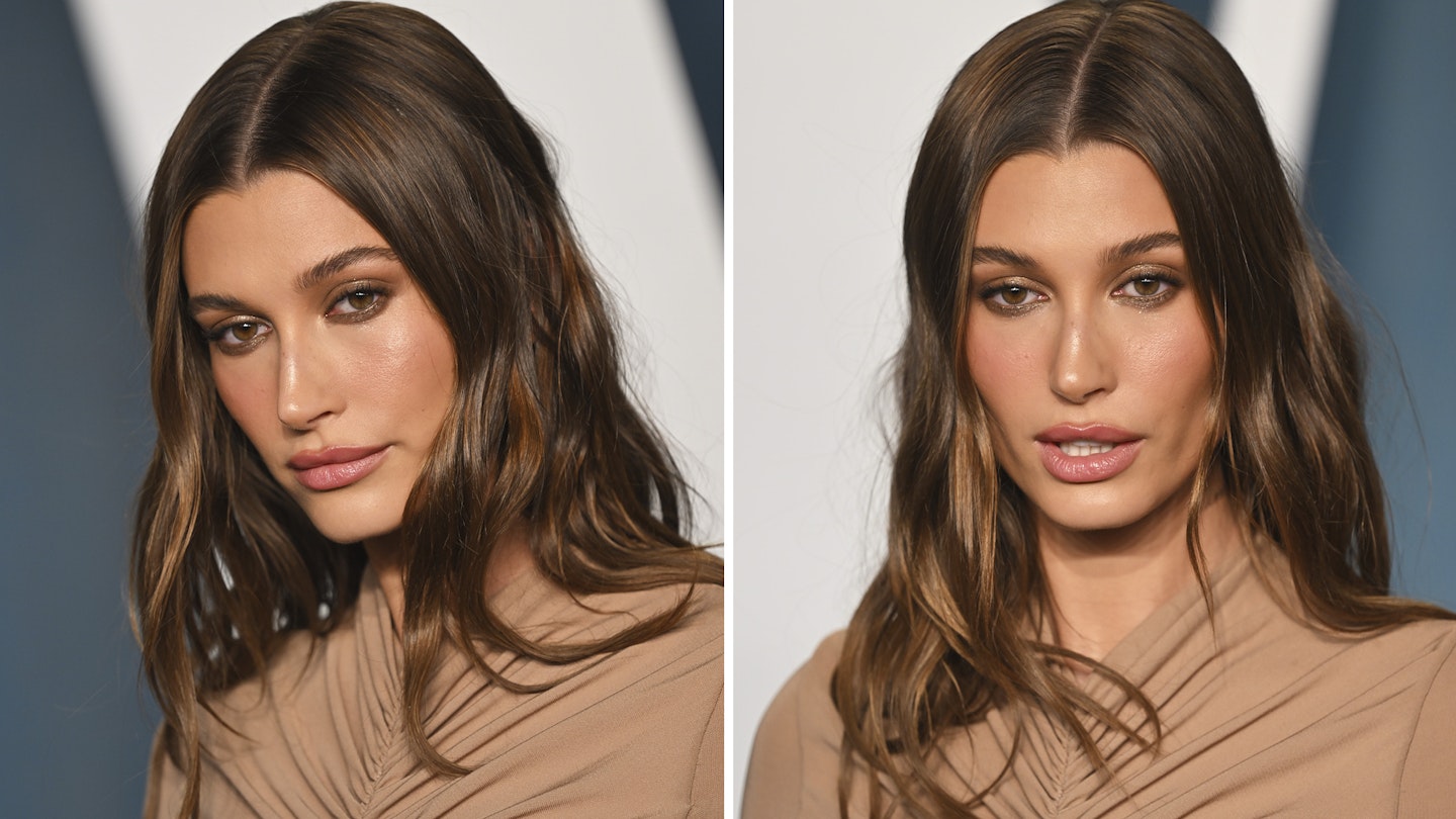 Close-up portrait of a young woman with freckles and flowing hair, captured in warm lighting.
