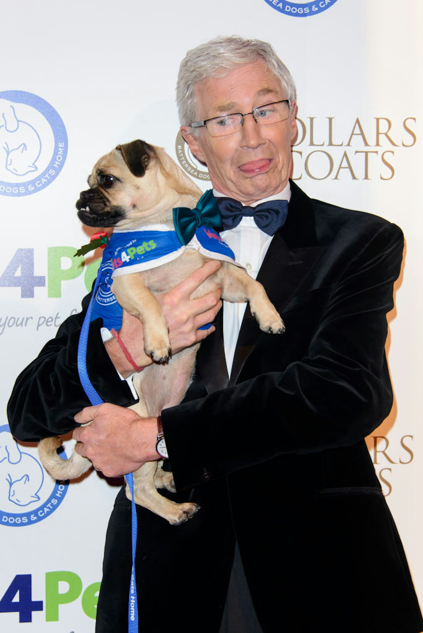 Paul O'Grady holding a dog whilst pulling funny face at awards show