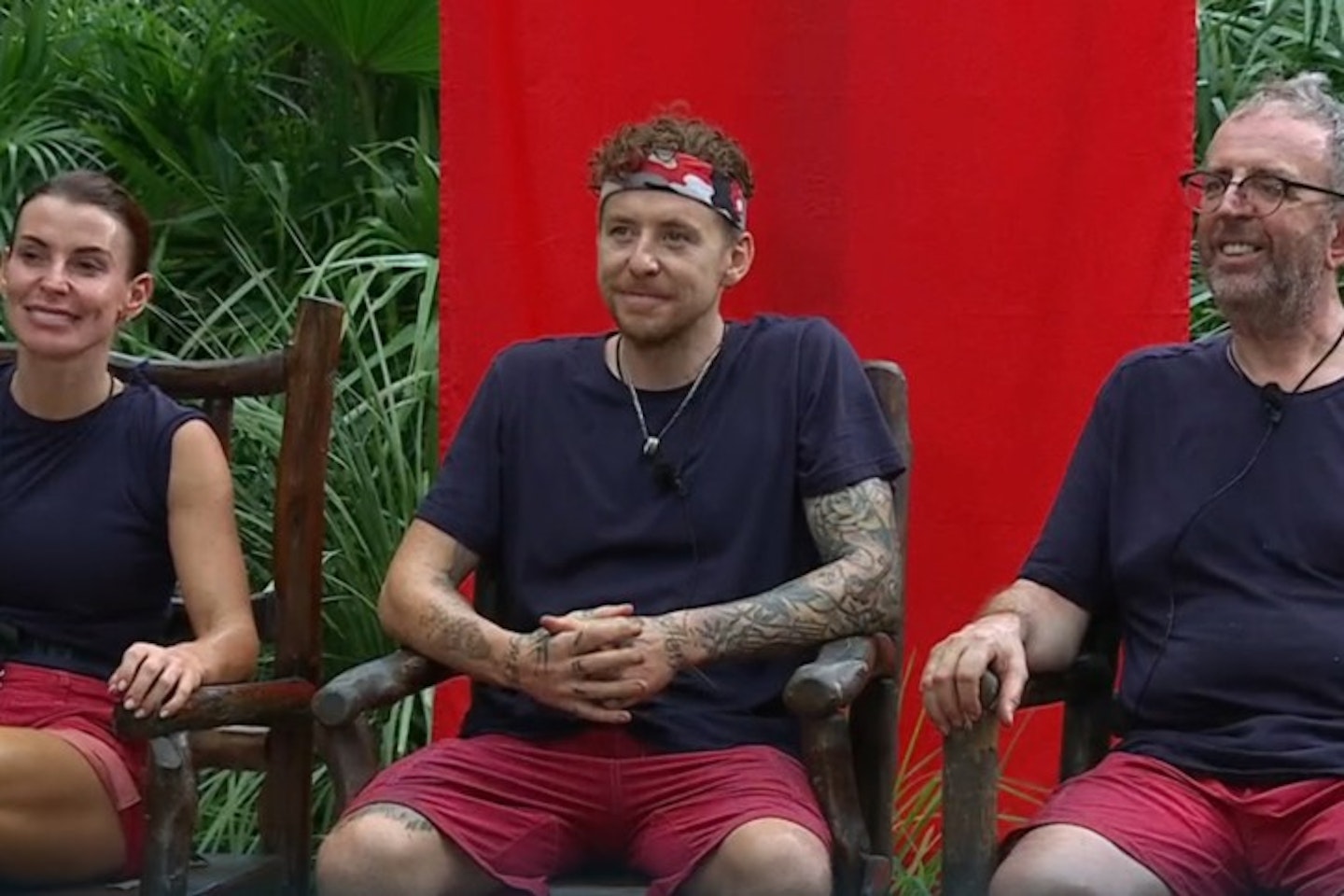 Coleen Rooney, Danny Jones and Reverend Richard Coles sit on chairs in the I'm A Celebrity jungle