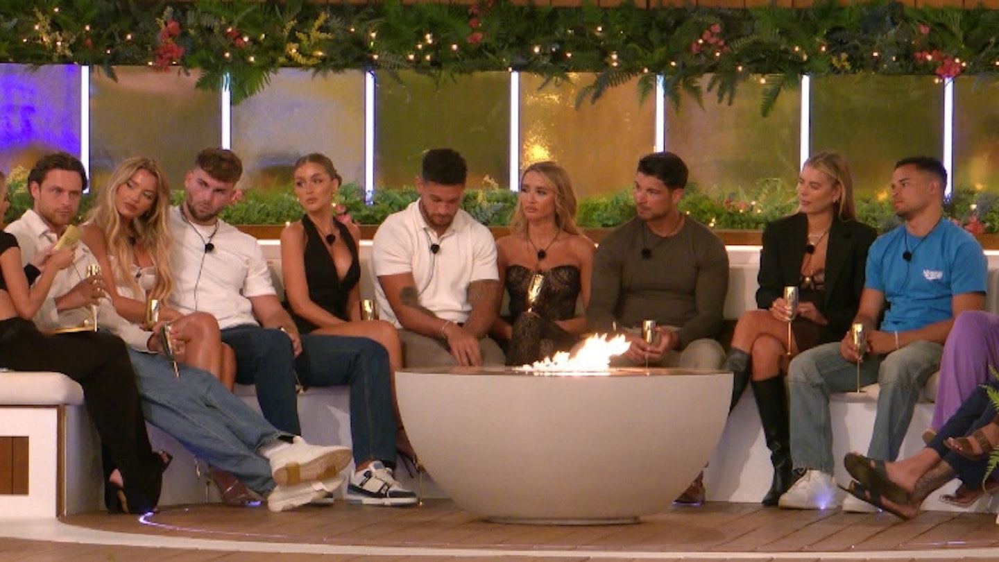 Love Island All Stars cast sit around the firepit playing a game