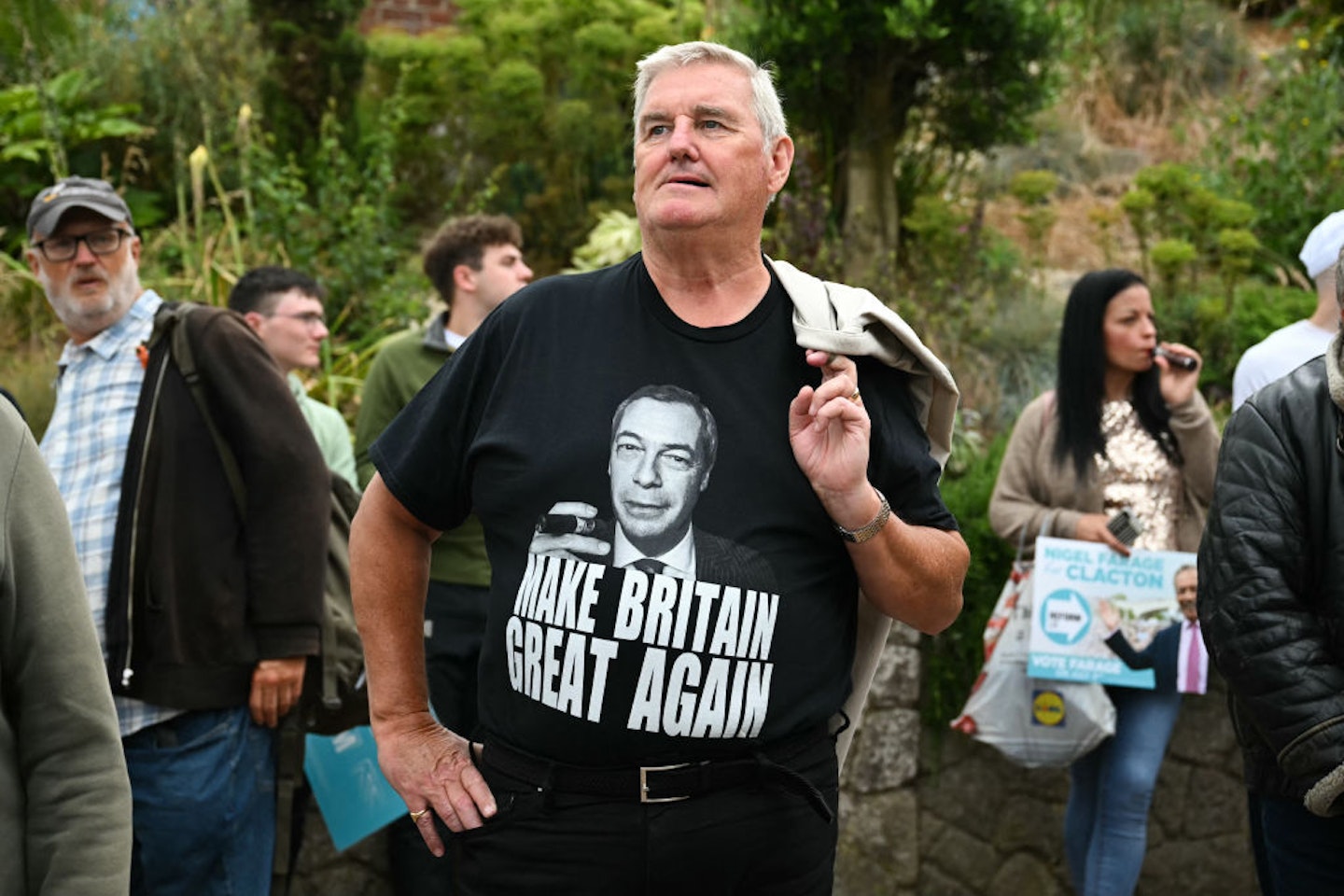 A supporter wearing a t-shirt that reads "make Britain great again" arrives before leader of Reform UK Nigel Farage delivers a speech during a general electiby campaign event by Clactby Pier