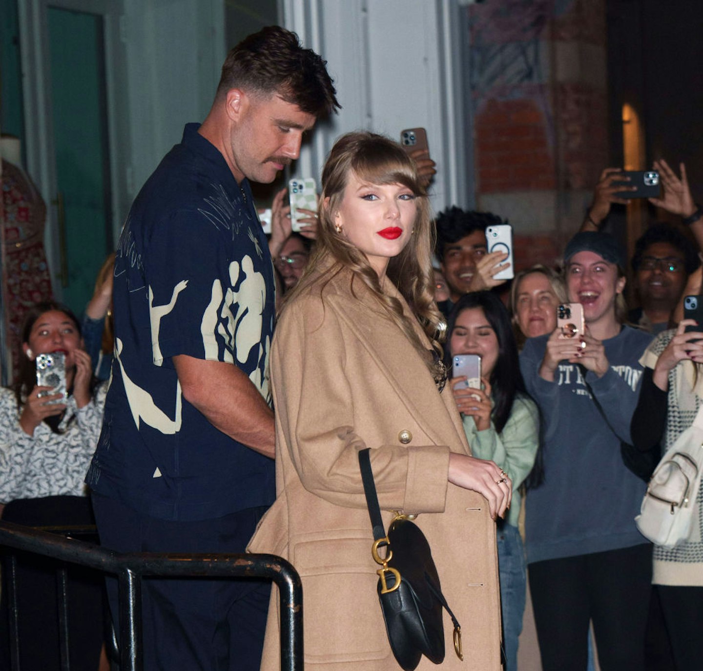 Taylor Swift in her characteristic red lip with Travis Kelce