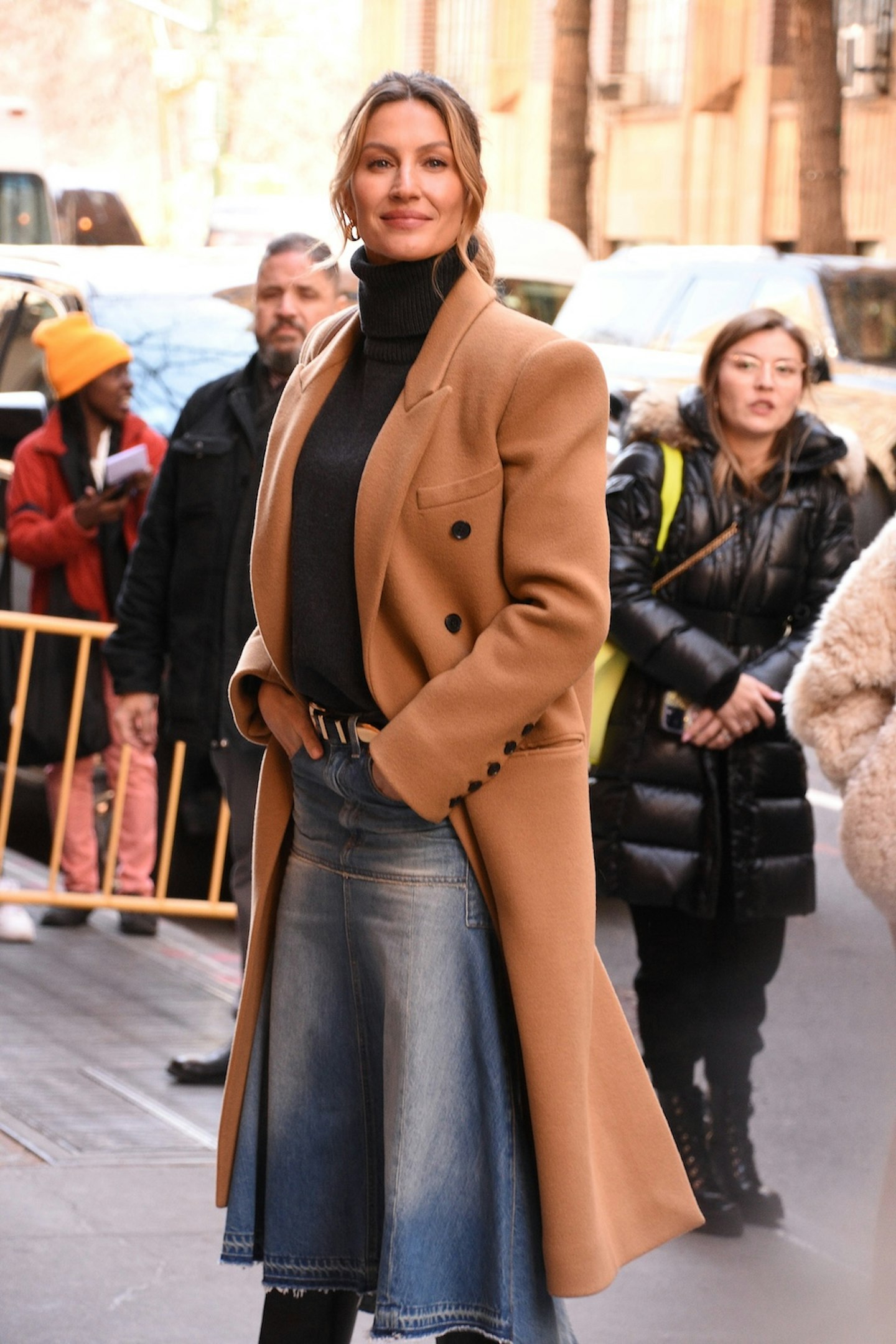 Gisele Bundchen wearing a camel coat and black polo neck