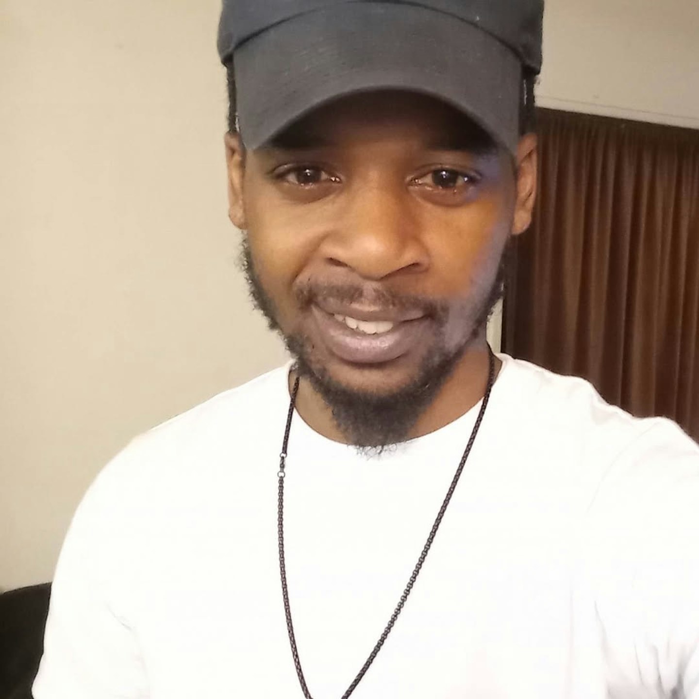 Rymir Satterthwaite wears a black cap and white t-shirt