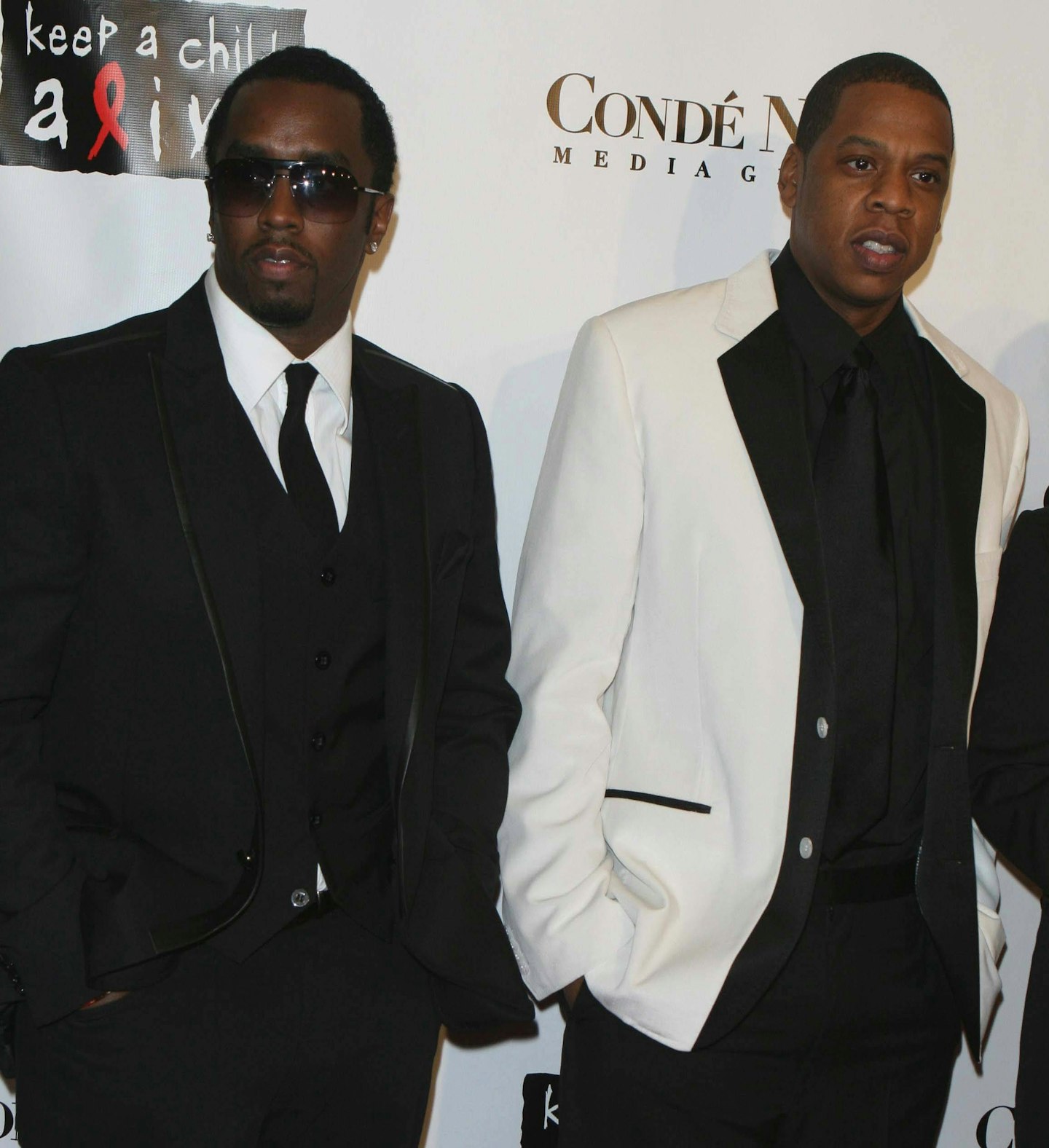 Diddy and Jay-Z wearing suits on a red carpet