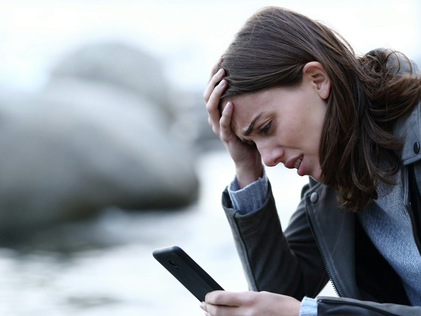 Woman looking stressed at mobile phone