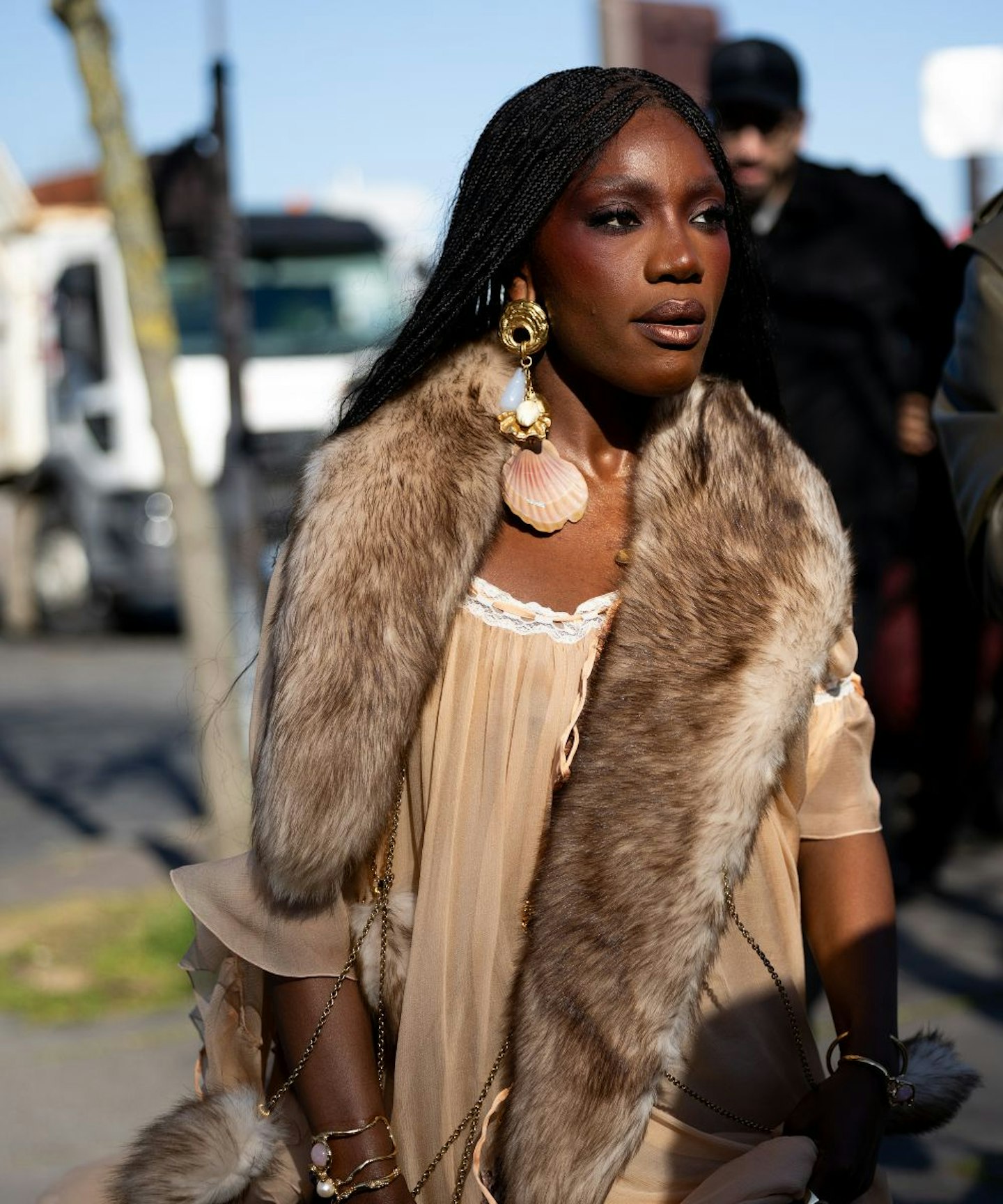 Doechii wears a beige Chloé dress and seashell earrings outside Chloé show