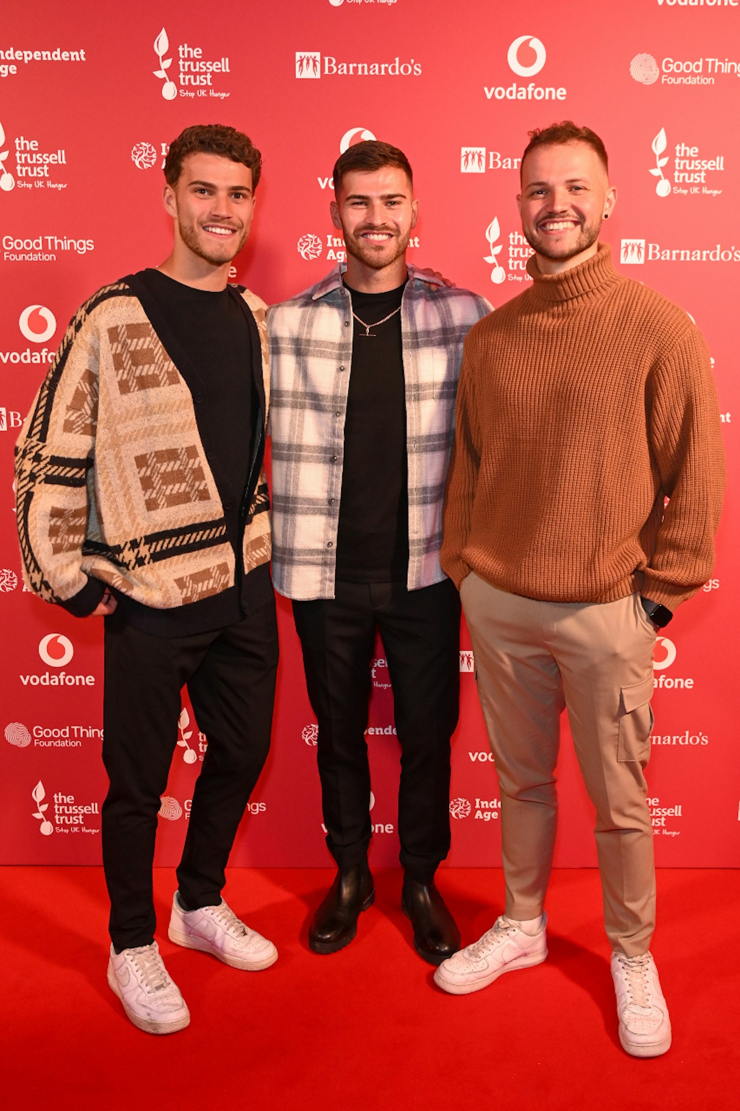 Owen Warner posing on a red carpet with his brother Jake and Louie