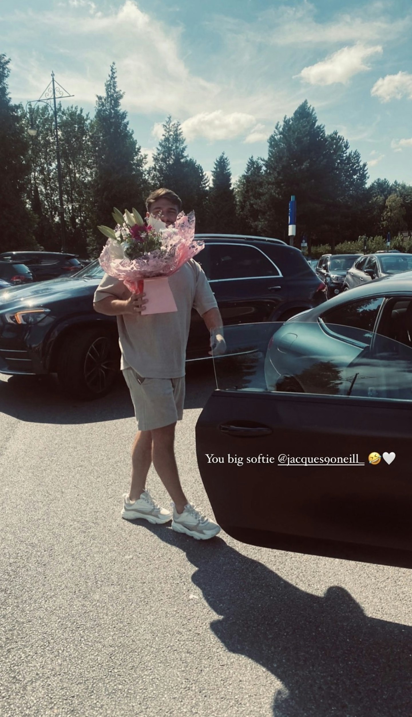 Jacques O'Neill holding a huge bouquet of flowers for Claudia Fogarty