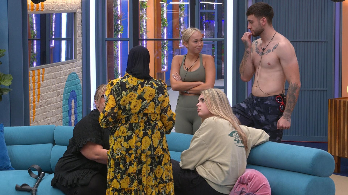 Housemates talk around sofas