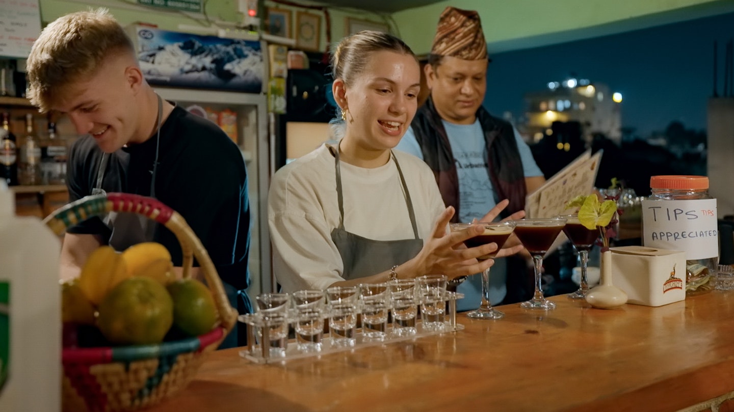 Fin and Sioned working behind a bar on Race Across The World