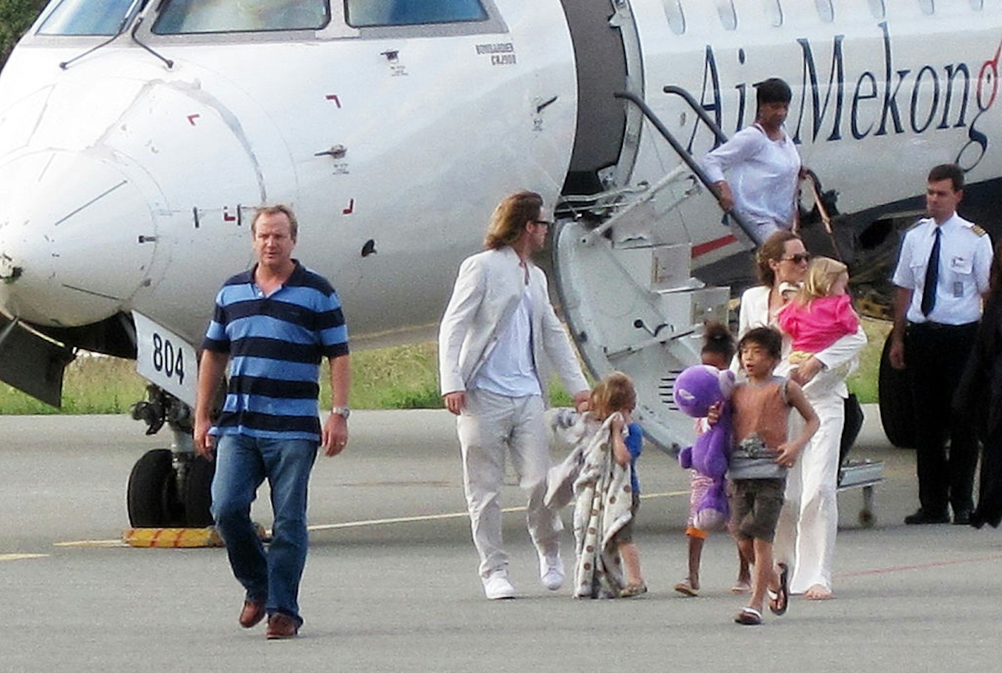Hollywood stars Angelina Jolie (R) and Brad Pitt (2nd-L) get off a plane with their children at the Con Son Airport on Con Dao island, offshore of Ba Ria Vung Tau province in Vietnam on November 11, 2011.