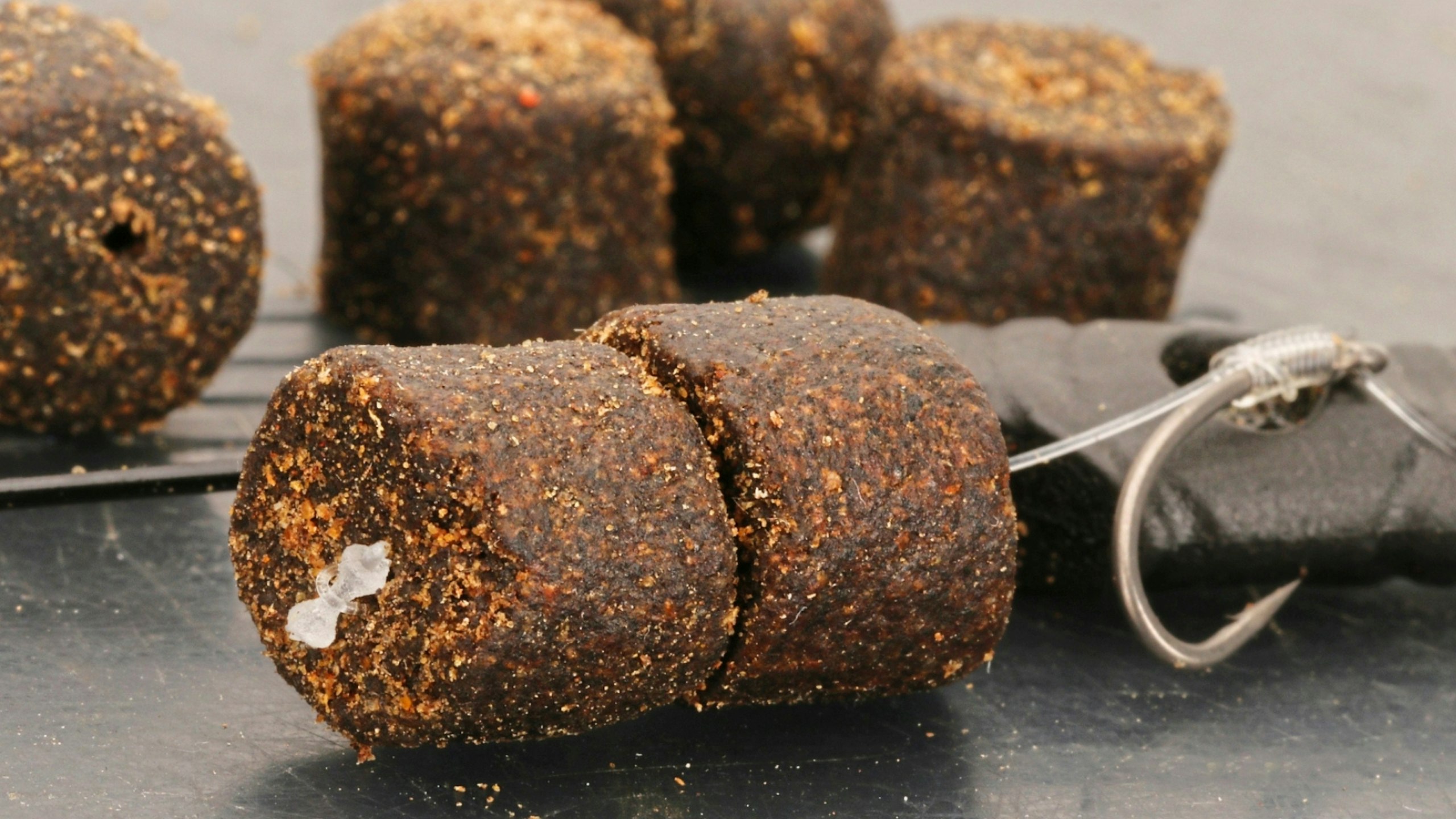 Close-up of hair-rigged fishing pellets attached to a hook and bait band.