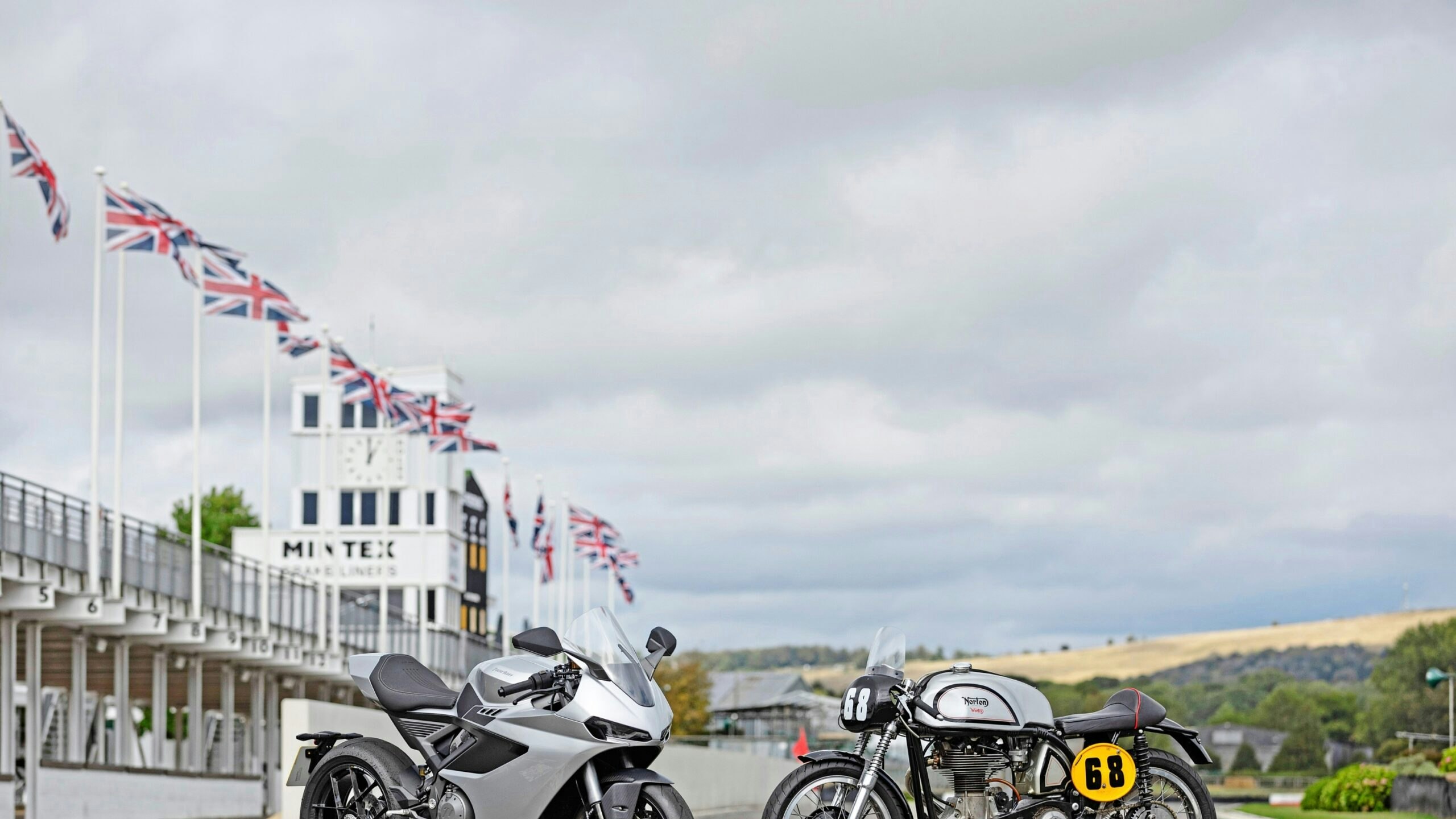 Norton Manx R and Manx Norton faced next to each other on a race track