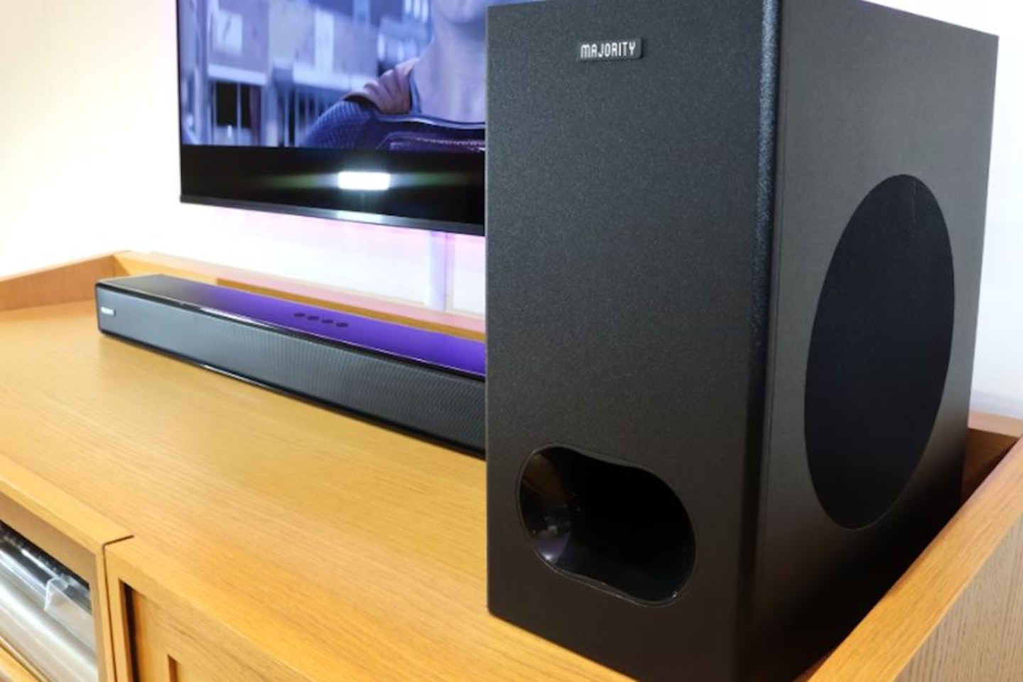 Majority Sierra Plus Dolby Atmos 2.1.2 Soundbar with Wireless Subwoofer next to a TV. Best budget soundbars, the best soundbar under £200.