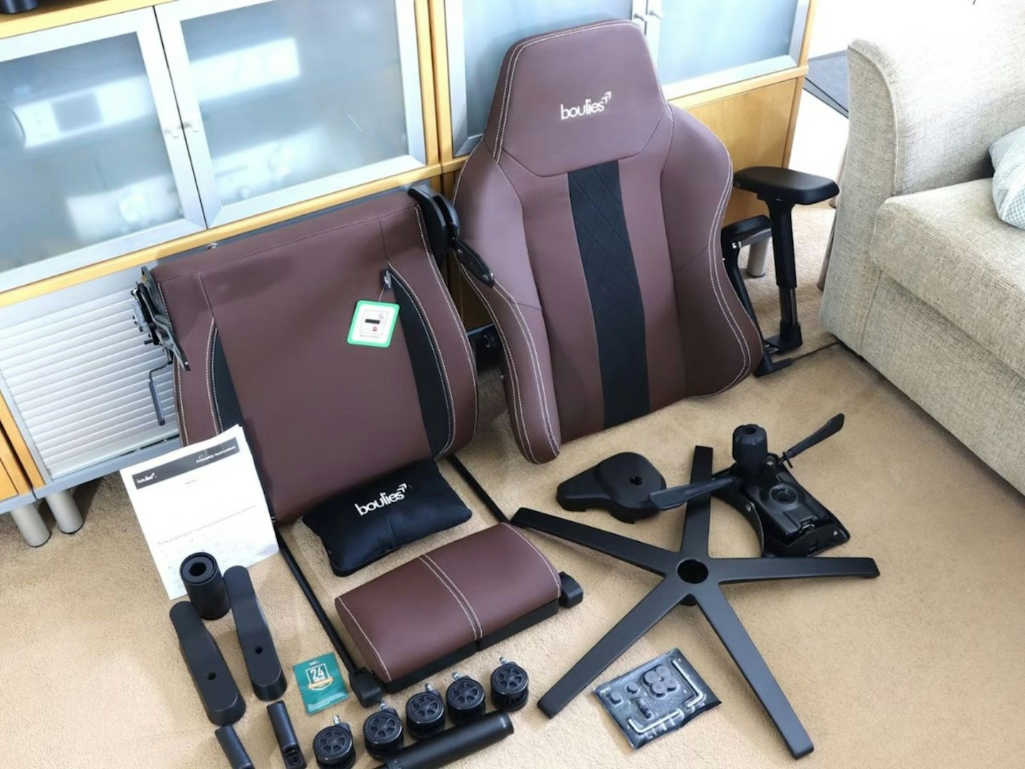 A Boulies Master Rex gaming chair in kit form with components in a living room - the best ergonomic gaming chair of 2025