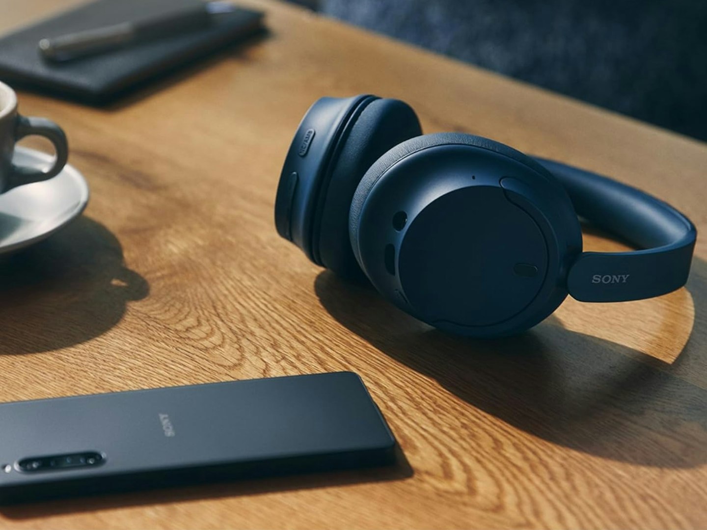Sony WH-CH720N Wireless Noise Cancelling Headphones on table with phone and cup. Best tech gifts.
