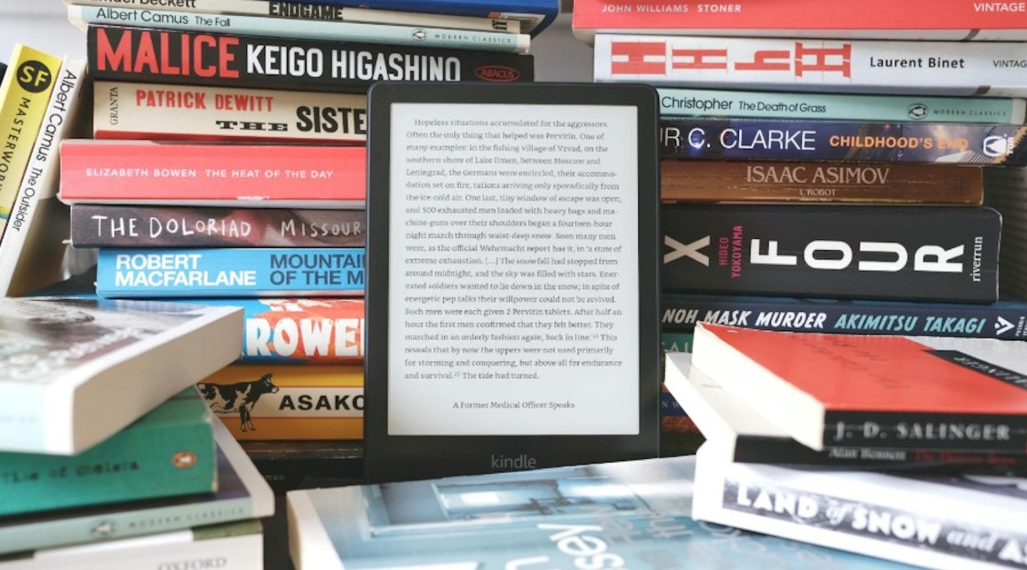 Kindle Paperwhite surrounded by books. Best tech gifts.