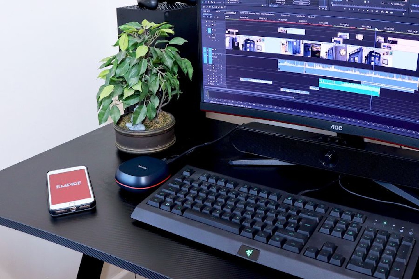 SanDisk Desk Drive portable SSD on a desk with phone, keyboard and monitor