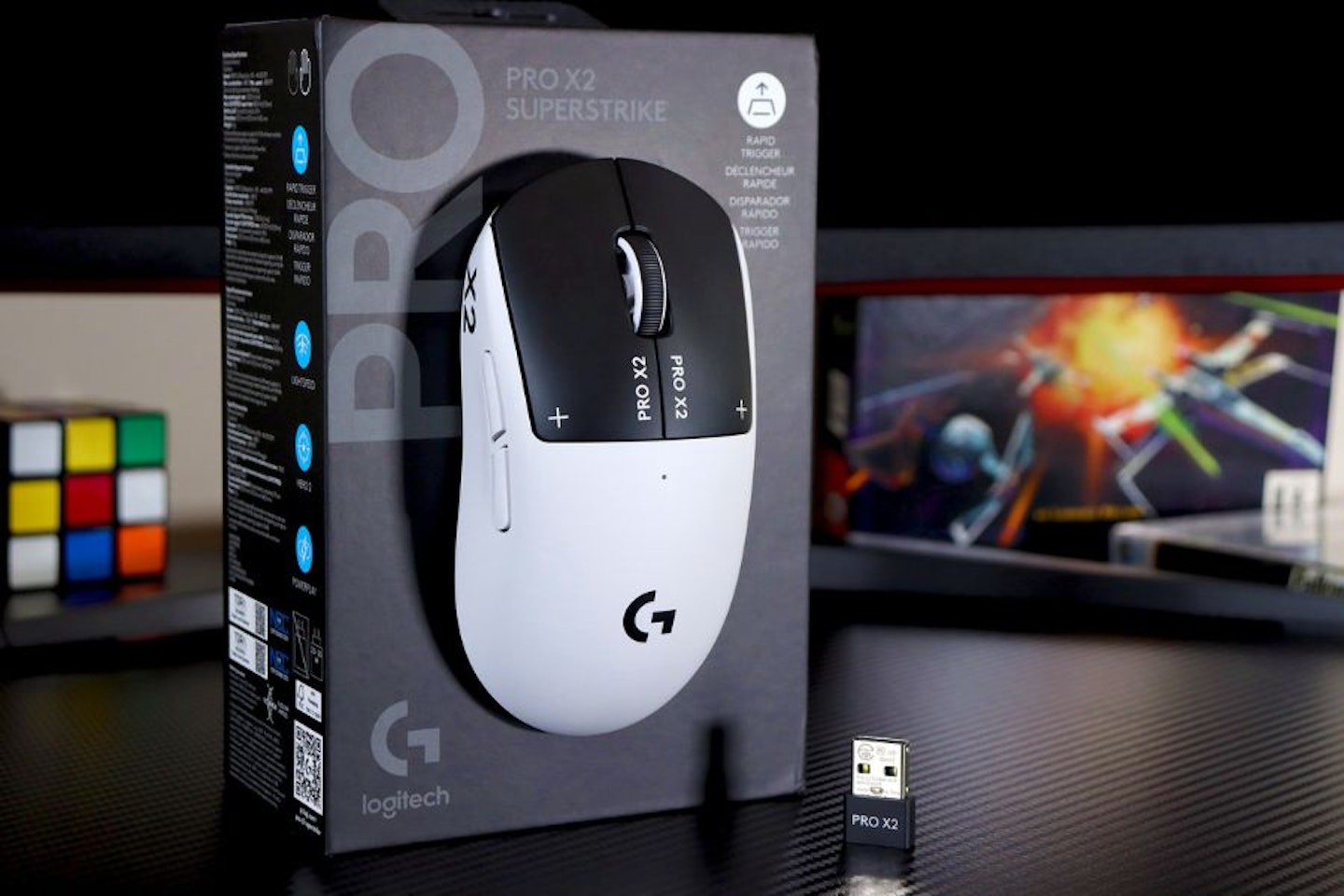 Logitech PRO X2 SUPERSTRIKE Gaming Mouse, box and accessories on a gaming desk
