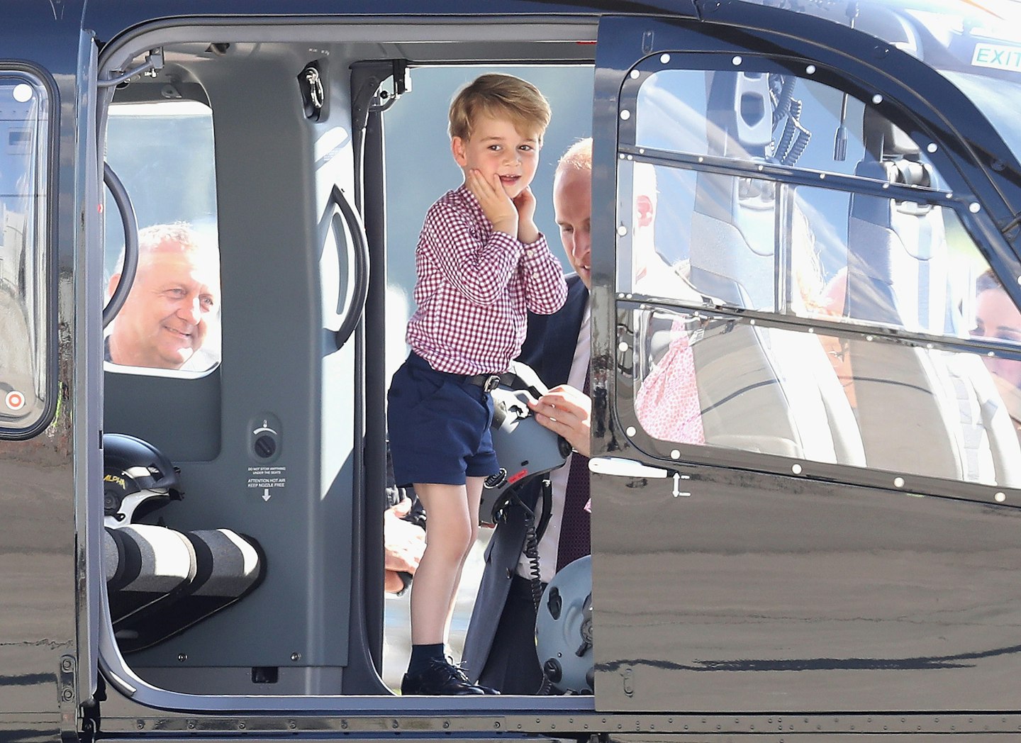 Prince George sits in the cockpit of a helicopter