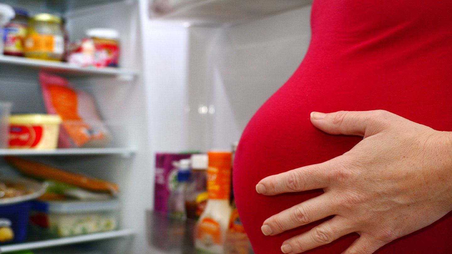 pregnancy cravings pregnant woman by fridge