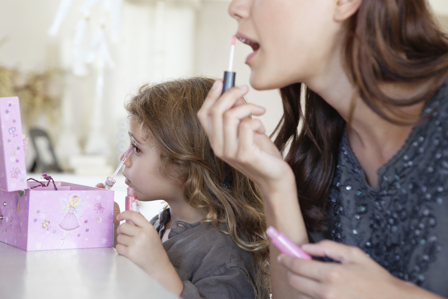 Mother and daughter applying make-up