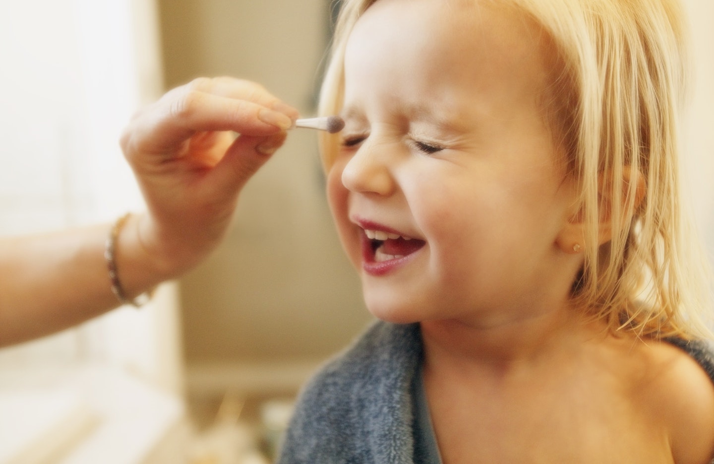 Mother and daughter applying make-up