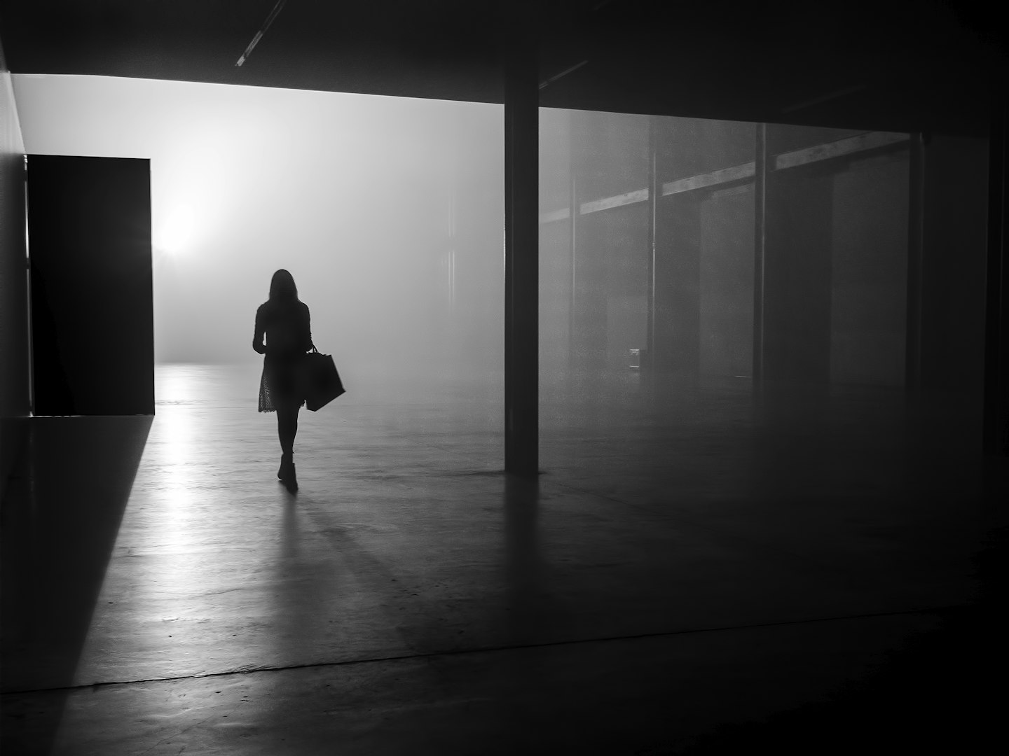 Silhouette of woman stands alone in empty street