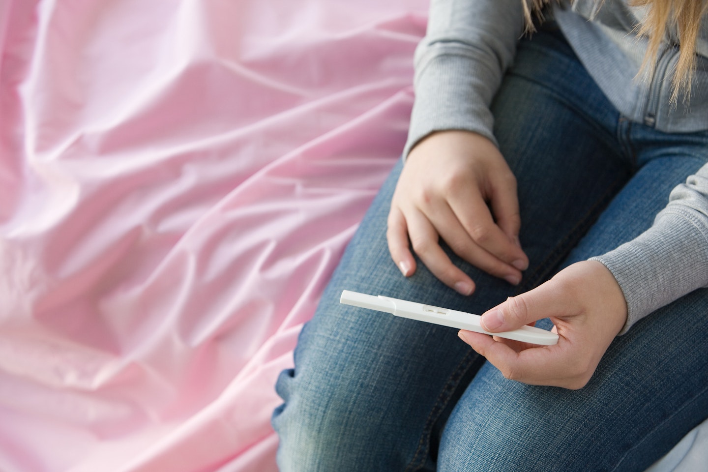 Stock image of a young girl looking at a pregnancy test