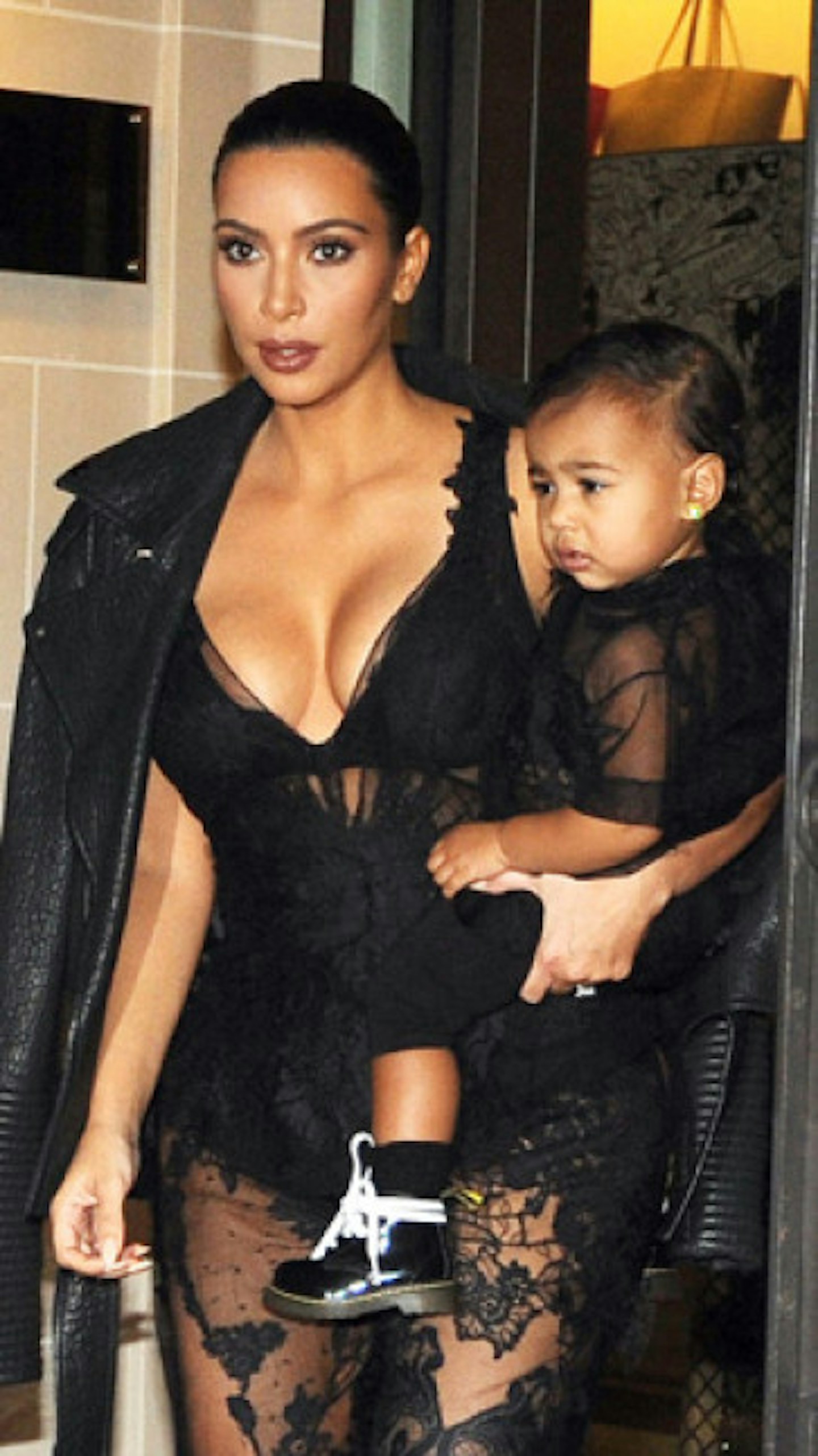 Kim leaves her Paris hotel with North dressed in matching outfits