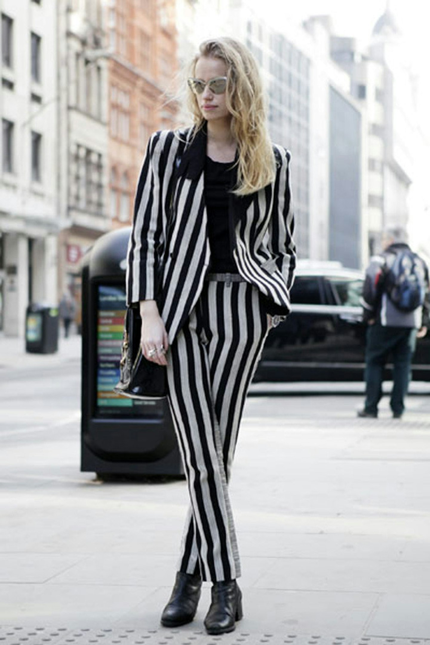 Abbey Wilson wearing a Costume National suit, vintage Versace bag and Prism glasses