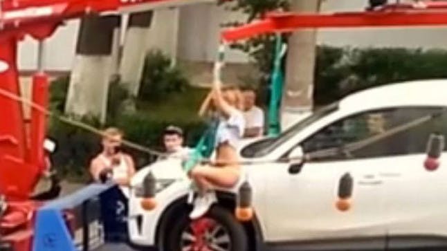 WATCH Woman strips off and performs striptease routine to stop police towing her car %%channel_name%%