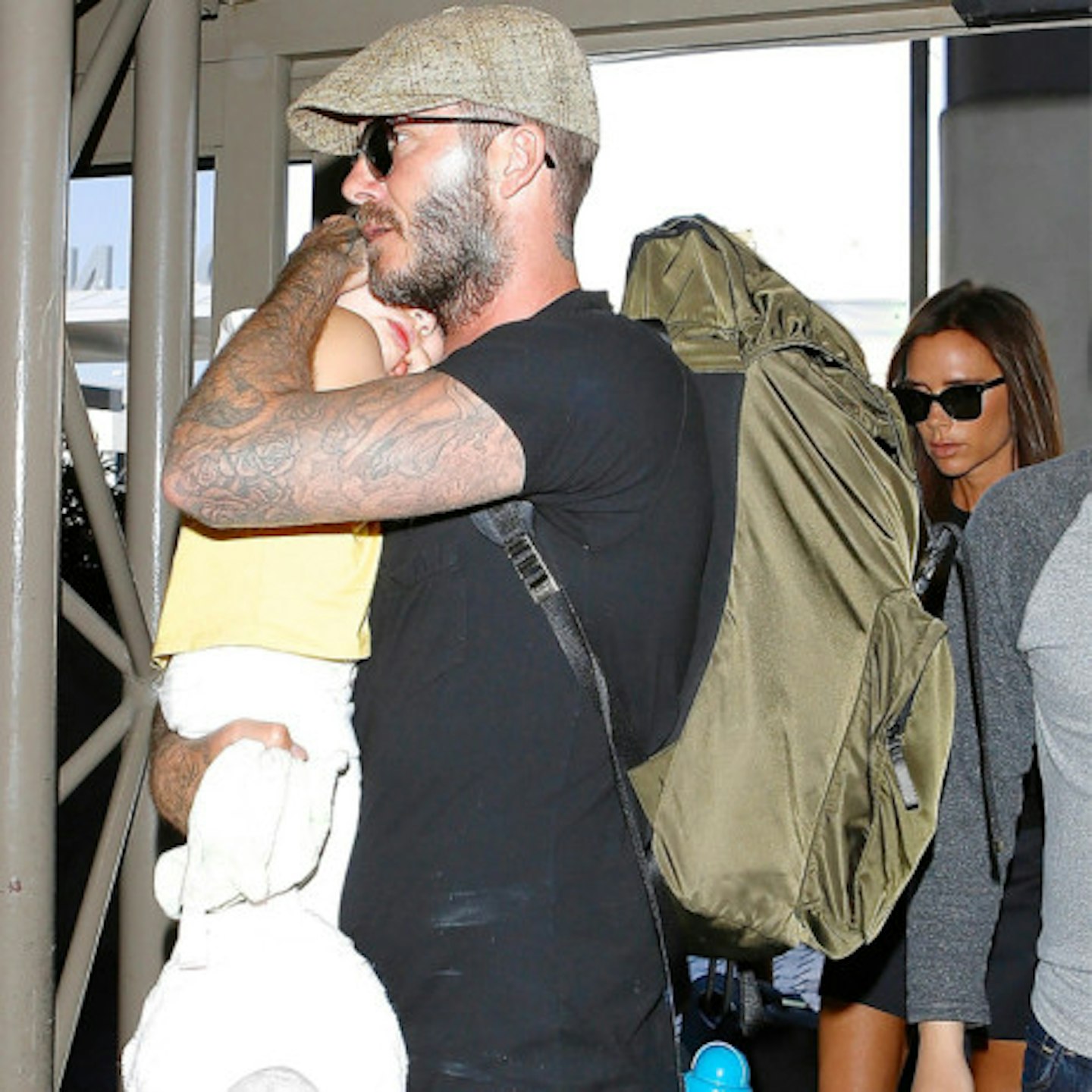 David looked serious as he held his daughter while walking through the airport