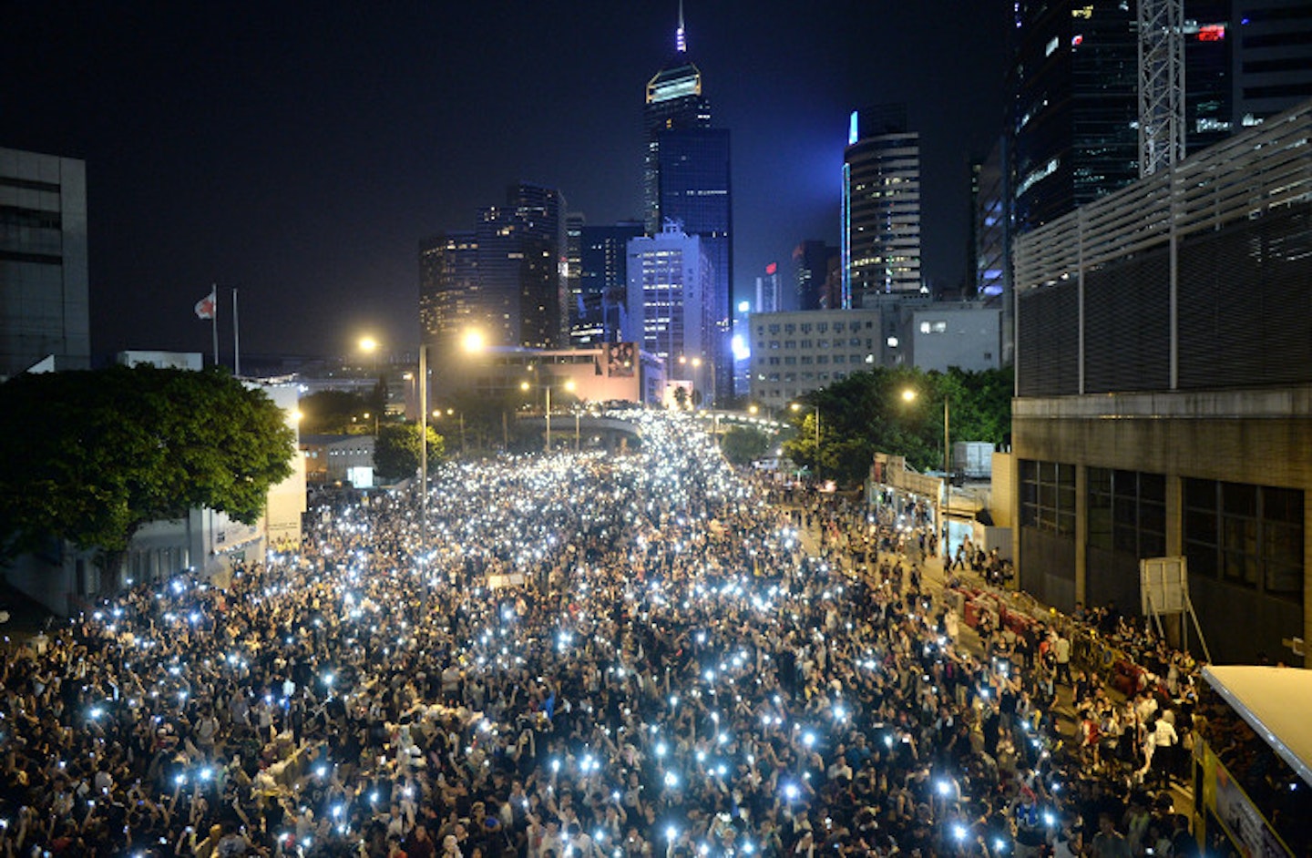 Pro-democracy demonstrators hold up their mobile phones during a protest near the Hong Kong government headquarters on September 29, 2014
