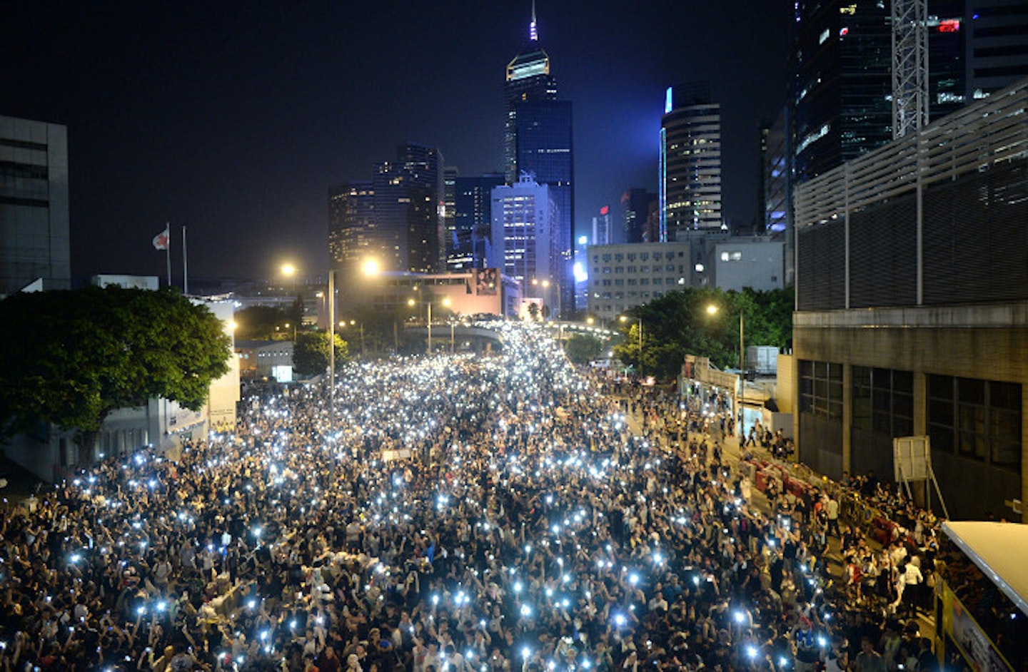Pro-democracy demonstrators hold up their mobile phones during a protest near the Hong Kong government headquarters on September 29, 2014