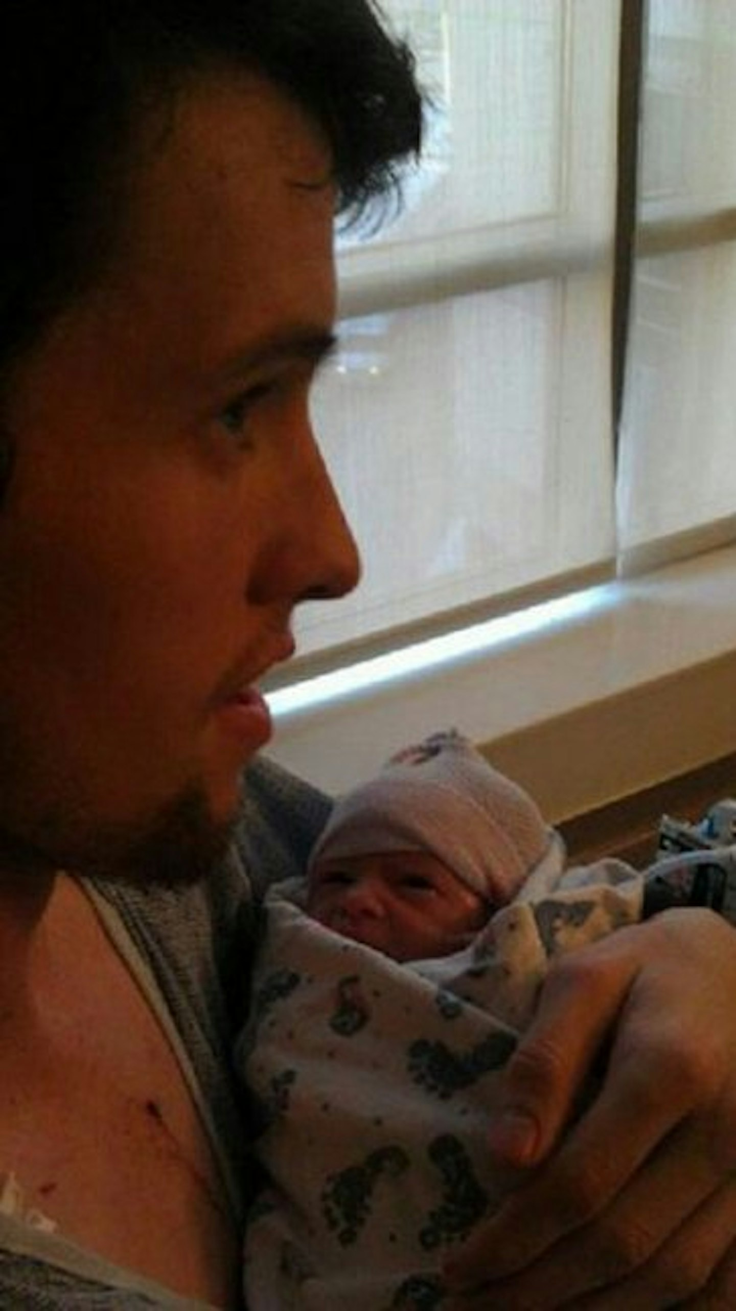 Josh cradling his newborn son in his arms (KFL News)
