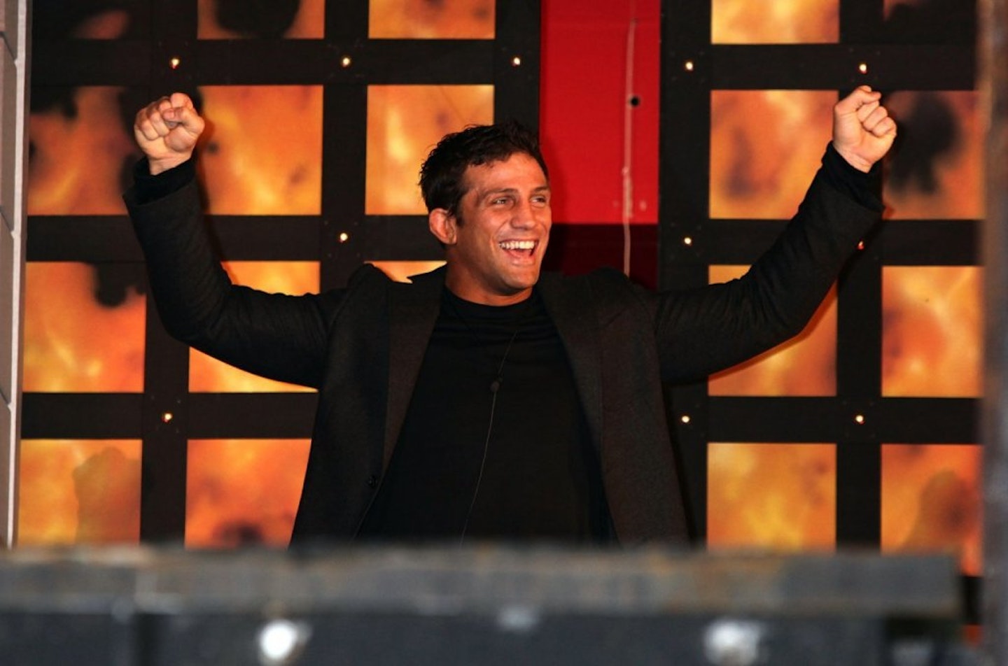 Alex Reid celebrating by holding arms up in the air
